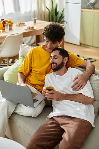 Two men share a cozy moment at home, enjoying coffee and each others company in casual attire. — Stock Photo