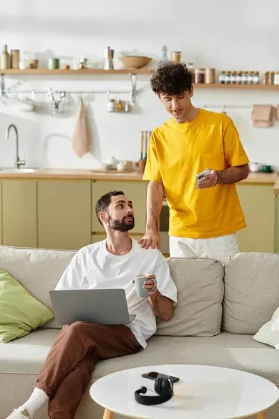 Two men enjoy each others company in casual clothes while relaxing at home together. — Stock Photo