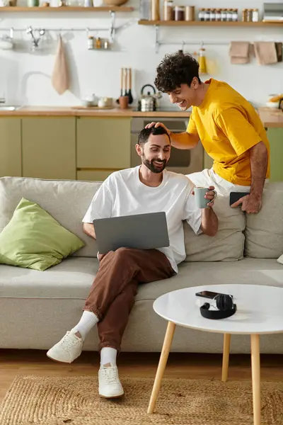 Two men share laughter and affection while relaxing in their stylish home, celebrating love. — Stock Photo