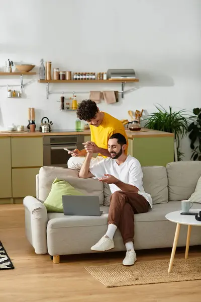 Two happy men enjoy each other's company while relaxing at home in their modern apartment. — Stock Photo