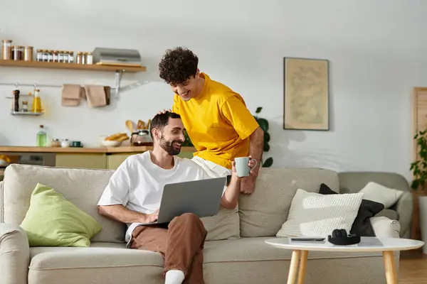Two men share a sweet moment in their modern apartment while working and relaxing together. — Stock Photo