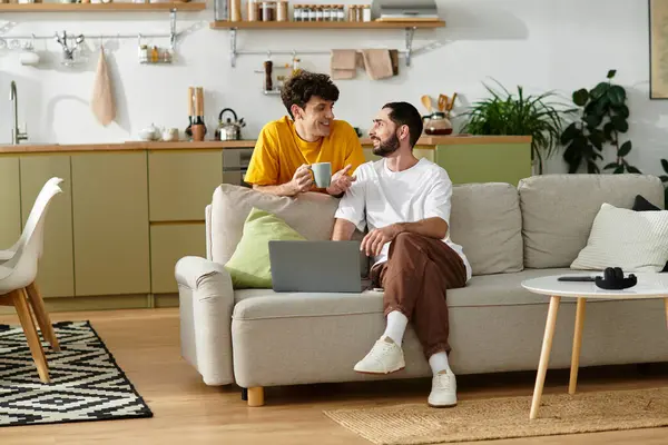 Two men share joyful moments in a stylish apartment, savoring each others company over coffee. — Stock Photo