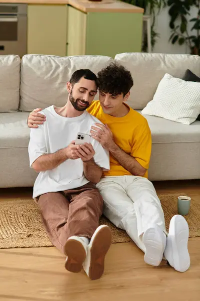 Two men share a tender moment, enjoying time together on the floor of their stylish home. — Stock Photo