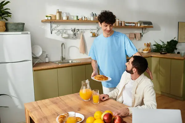 Deux hommes chérissent un petit déjeuner fait maison ensemble, embrassant l'amour et le mode de vie dans leur maison confortable. — Photo de stock