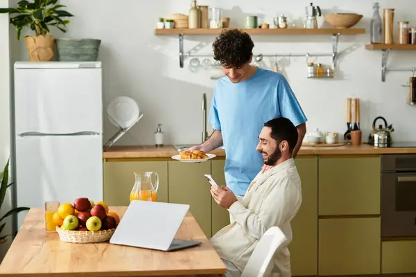 Two men enjoy a cheerful breakfast together in their modern kitchen, connecting over food and love. — Stock Photo