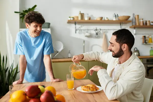 Due uomini condividono un'accogliente colazione insieme a casa, godendo di conversazione casuale e cibo delizioso. — Foto stock