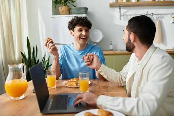 Two men share a delightful breakfast together in their stylish apartment, basking in morning light. — Stock Photo