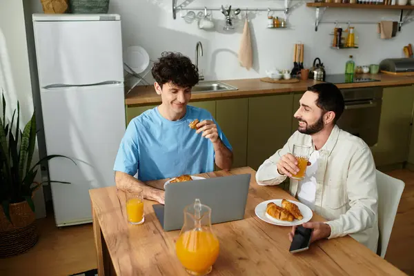 Two men share a delightful breakfast in their modern apartment, enjoying each others company. — Stock Photo
