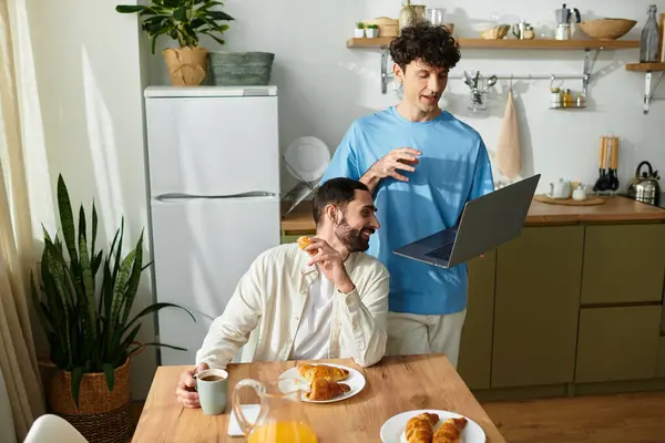 Two men enjoy a cozy breakfast in their stylish apartment, sharing love and laughter. — Stock Photo