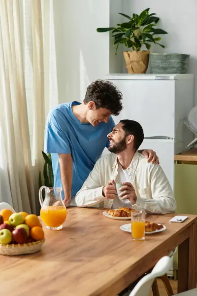 Two men share a warm breakfast in their modern apartment, celebrating love and togetherness. — Stock Photo