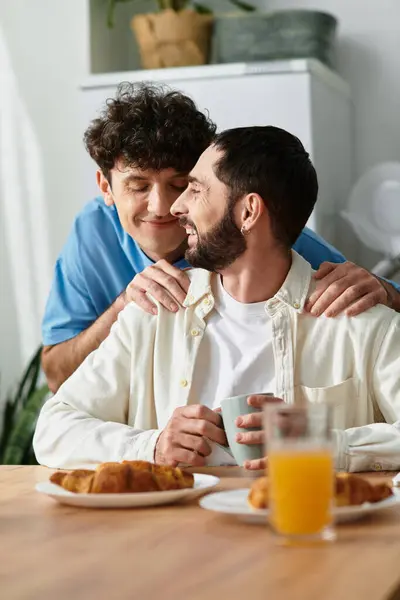 Due uomini godono di una colazione accogliente insieme, piena di amore e calore nella loro casa moderna. — Foto stock