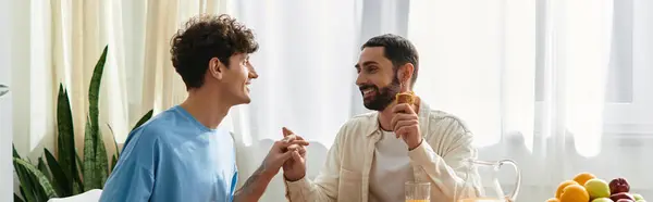 Two men enjoy a loving breakfast together in their modern apartment filled with morning light, banner — Stock Photo
