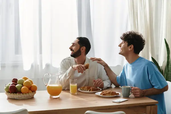 Two gay men share a joyful breakfast at their stylish apartment, savoring each others company. — Stock Photo