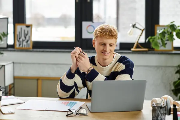 A young redhead man in a striped sweater engages with colleagues in a modern workspace. — Stock Photo