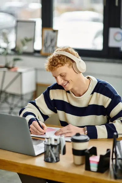 A redhead man in a striped sweater focuses on tasks in a contemporary office space. — Stock Photo