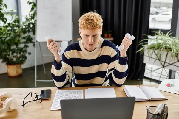 Jeune professionnel en pull rayé se concentre sur le travail à son ordinateur portable au milieu de la verdure. — Photo de stock