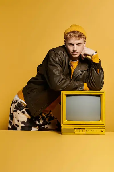 Young model showcases a chic winter outfit against a vibrant yellow backdrop, exuding style. — Stock Photo