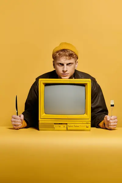 Homem elegante exibe uma roupa de inverno na moda com uma televisão vintage em um ambiente de estúdio brilhante. — Fotografia de Stock