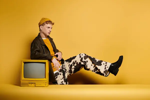 A young redhead man models a fashionable winter outfit with a playful twist in a studio. — Stock Photo
