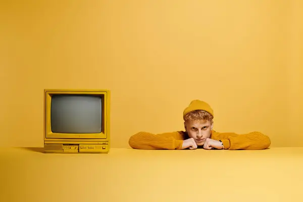 A fashionable young redhead rests his chin on his hands while dressed warmly in a trendy outfit. — Stock Photo