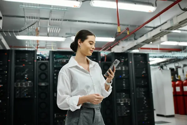 Uno specialista IT sta lavorando con attenzione su un dispositivo in un'elegante sala server piena di hardware. — Foto stock