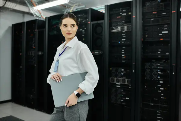 Una donna in camicia bianca gestisce i sistemi informatici in un data center professionale. — Foto stock