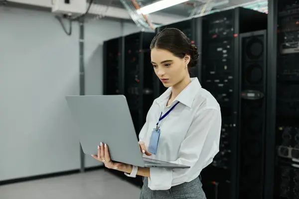 Una donna in camicia bianca gestisce un sistema informatico in una sala server high-tech. — Foto stock