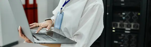 Una donna in camicia bianca lavora sapientemente in una moderna sala server, garantendo la sicurezza del sistema, banner — Foto stock