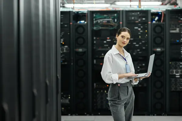 Uno specialista IT in camicia bianca lavora sodo in una moderna sala server per la gestione dei sistemi. — Foto stock
