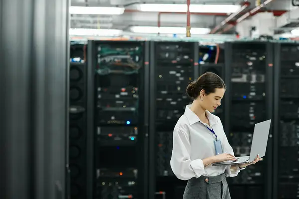 An IT specialist in a white shirt works diligently in a busy server room, handling technology. — Stock Photo