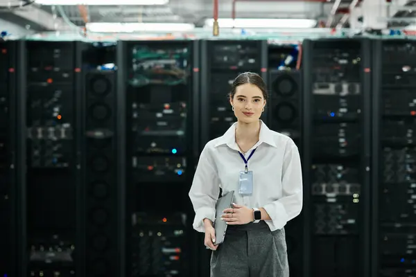 Uno specialista IT in camicia bianca supervisiona le operazioni in un'elegante sala server. — Foto stock