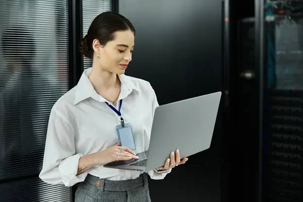 An IT specialist in a white shirt works diligently to ensure system security in a server room. — Stock Photo