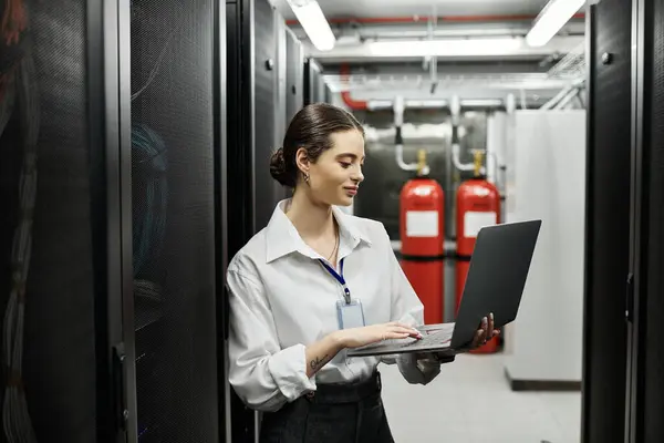 IT specialist works diligently in a sleek server room, ensuring digital systems run smoothly. — Stock Photo