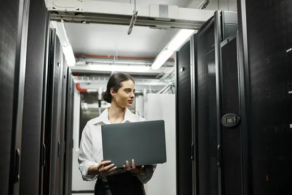 Uno specialista IT qualificato lavora diligentemente in una moderna sala server, gestendo sistemi digitali. — Foto stock