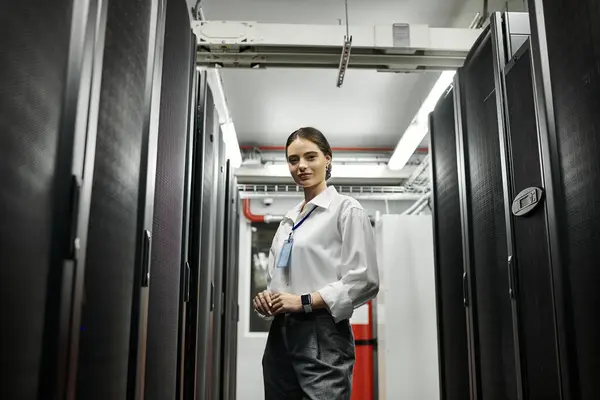 Eine qualifizierte Frau im weißen Hemd arbeitet fleißig inmitten hochentwickelter Server-Hardware in einem Rechenzentrum. — Stockfoto