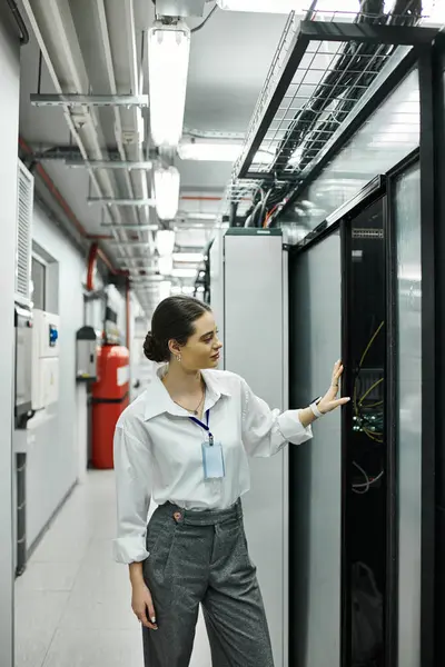 Una donna in camicia bianca gestisce hardware server all'interno di un data center contemporaneo. — Foto stock