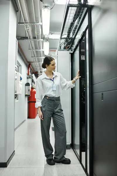 Specialista IT in una sala server elegante gestisce i sistemi informatici e garantisce la sicurezza digitale. — Foto stock