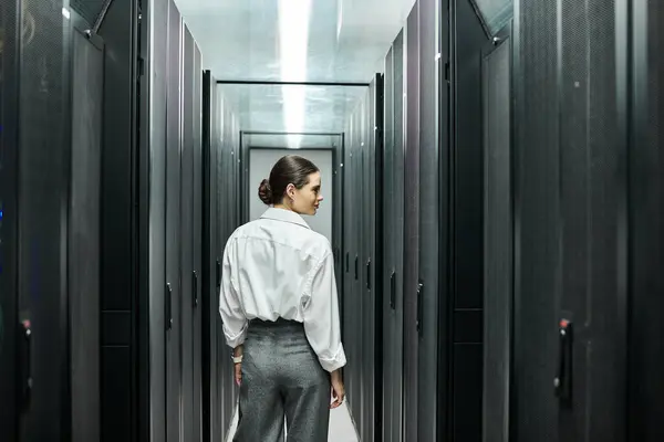 Eine professionelle Frau im weißen Hemd arbeitet fleißig in einem Rechenzentrum und überwacht die Server-Hardware. — Stockfoto