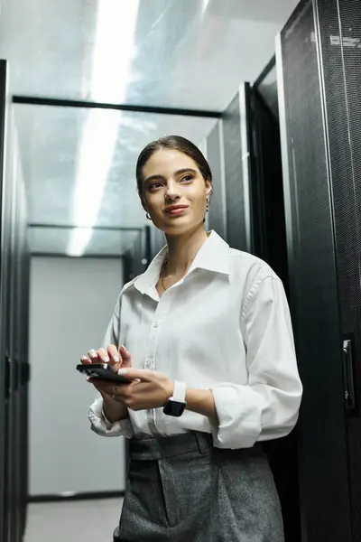 Eine Frau im weißen Hemd arbeitet fleißig in einem schlanken Serverraum voller fortschrittlicher Technologie.. — Stockfoto