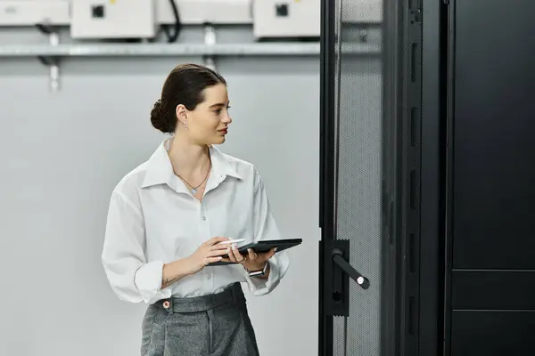 Konzentrierter IT-Spezialist arbeitet fleißig in einem modernen Serverraum und überwacht Systeme. — Stockfoto