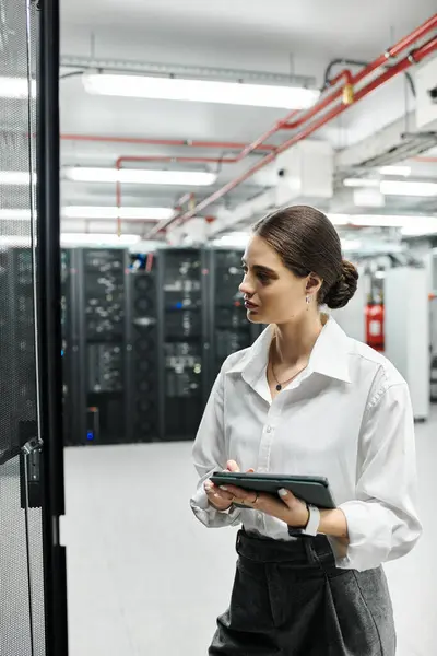 Eine professionelle Frau im weißen Hemd ist im Rechenzentrum mit Server-Hardware beschäftigt. — Stockfoto