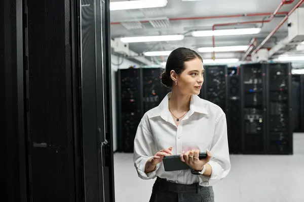 Eine qualifizierte Frau im weißen Hemd überprüft den Serverbetrieb in einer modernen IT-Einrichtung. — Stockfoto