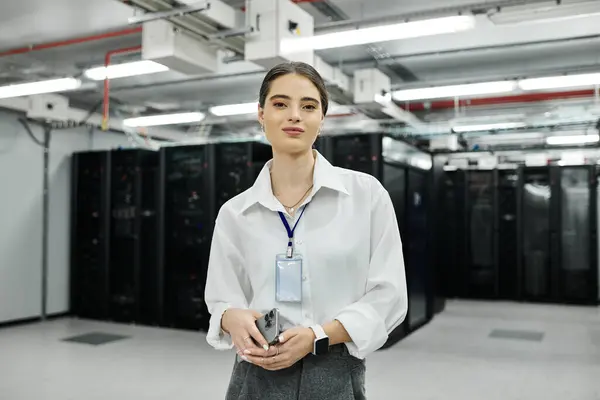 A skilled woman in a white shirt confidently oversees server operations in a tech hub. — Stock Photo