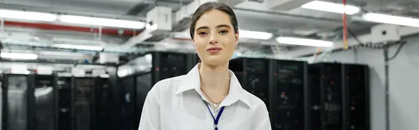 Una donna in camicia bianca lavora con fiducia in una sala server high-tech, gestendo sistemi, banner — Foto stock