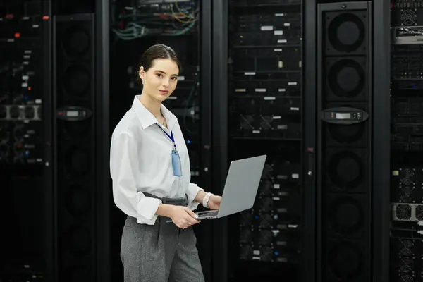 Eine Frau im weißen Hemd arbeitet effizient in einem schlanken Serverraum und zeigt ihr technisches Know-how. — Stockfoto