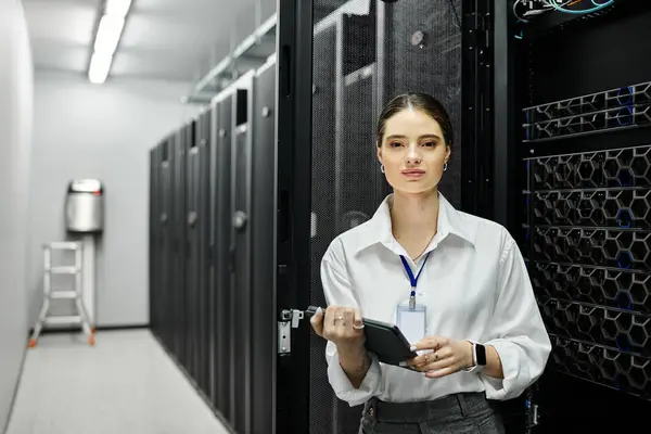 Eine Frau im weißen Hemd überwacht effizient die Netzwerksysteme in einem Serverraum. — Stockfoto