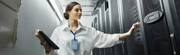 Specialista in una camicia bianca monitora i sistemi server in un ambiente high-tech e professionale, banner — Foto stock