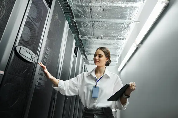 A woman in a white shirt manages server hardware in a contemporary data center setting. — Stock Photo