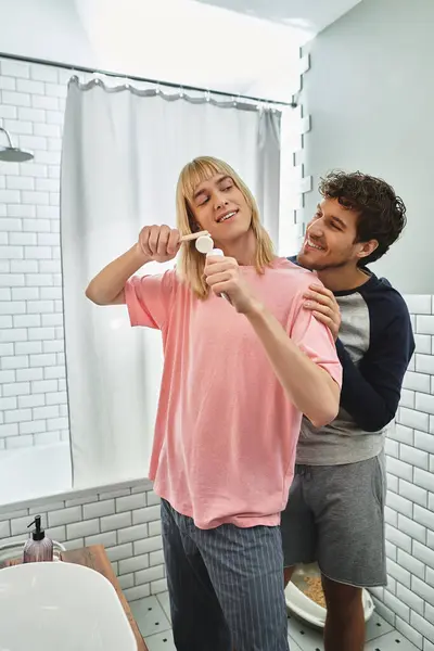 Two happy men enjoy their morning routine together in a bright, cheerful bathroom. — Stock Photo