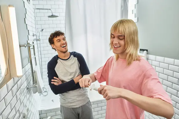 Due uomini si godono reciprocamente compagnia mentre si preparano in uno spazio bagno elegante e arioso. — Foto stock